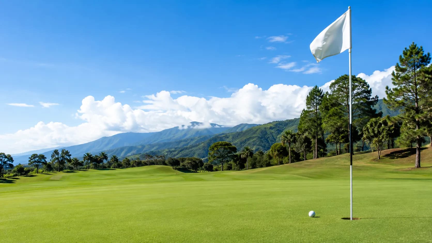 Campo de golf ParGo en un día despejado, con la bandera del hoyo y la cordillera al fondo